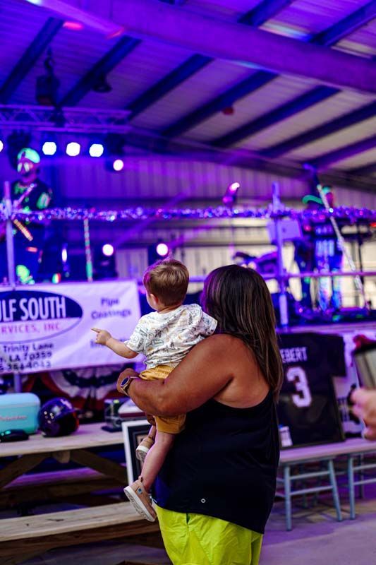 A woman is holding a baby in her arms at a concert.