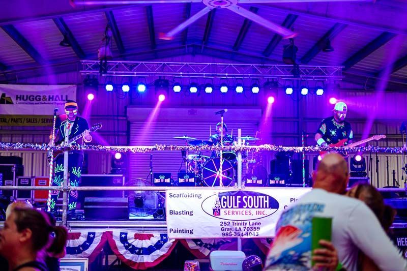 A group of people standing in front of a stage with a sign that says gulf south