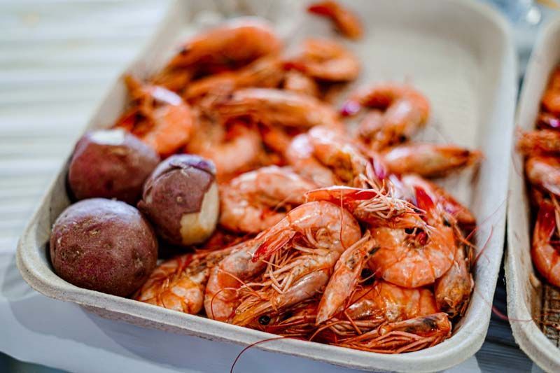 A tray of shrimp and potatoes on a table.