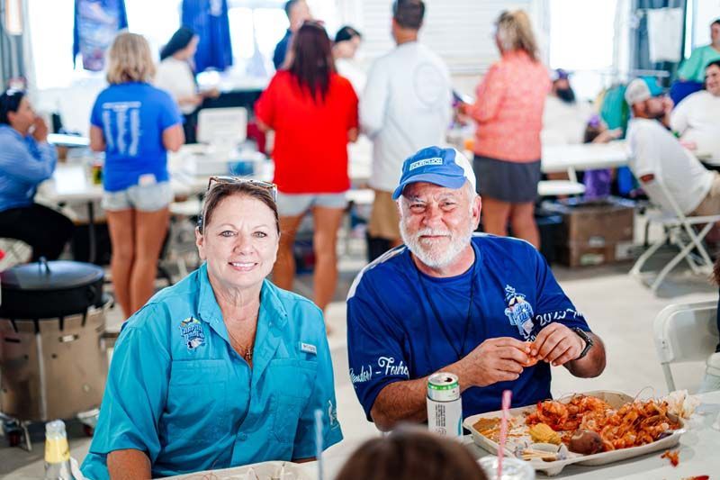 A man and a woman are sitting at a table eating food.