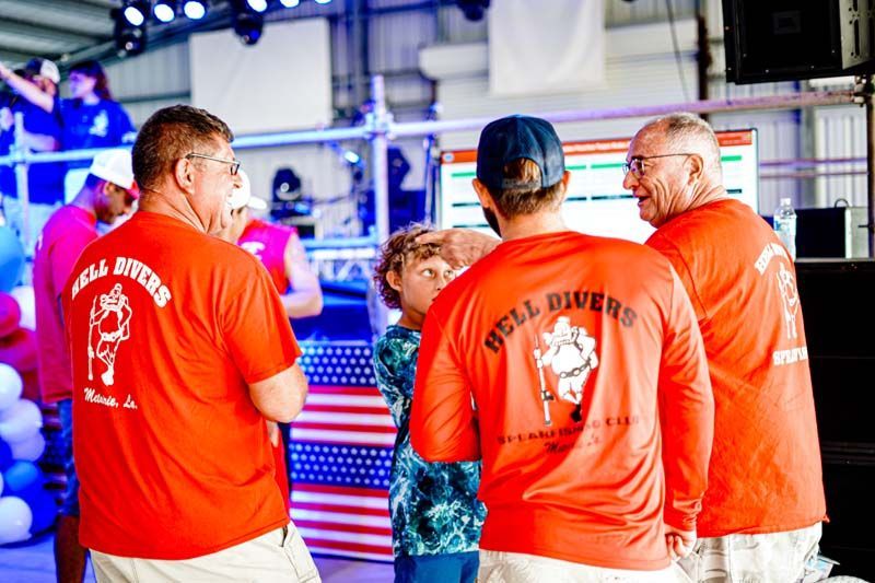 A group of men wearing red shirts are standing next to each other in a room.