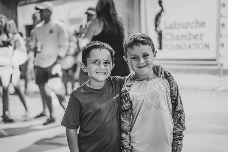 Two young boys are posing for a picture together in a black and white photo.