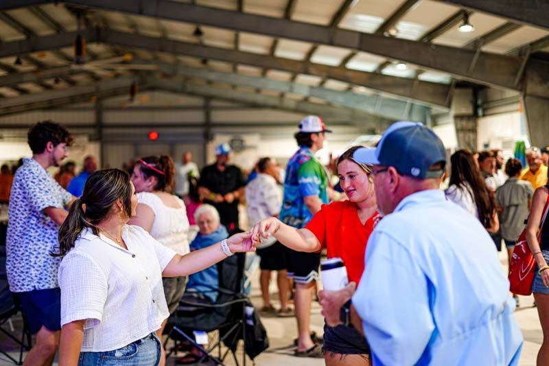 A group of people are dancing in a large room.