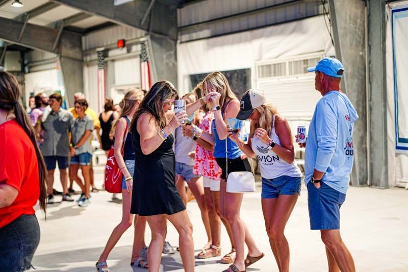 A group of people are standing in a room talking to each other.