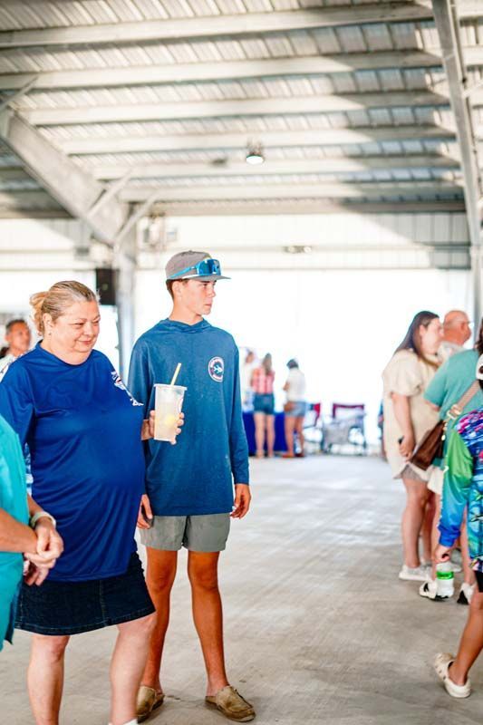 A group of people are standing in a room talking to each other.