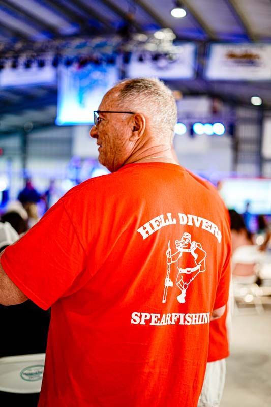 A man in a red t-shirt is standing in a room.