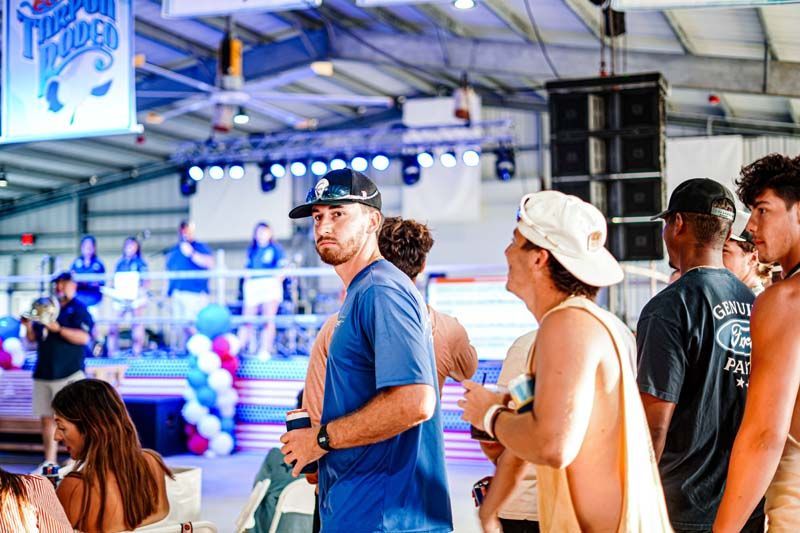 A group of people are standing in front of a stage at a party.