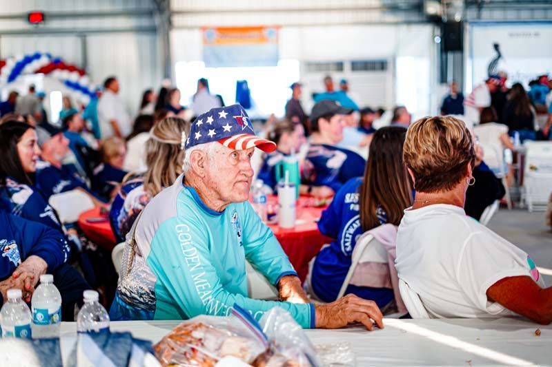 A man is sitting at a table in a crowd of people.
