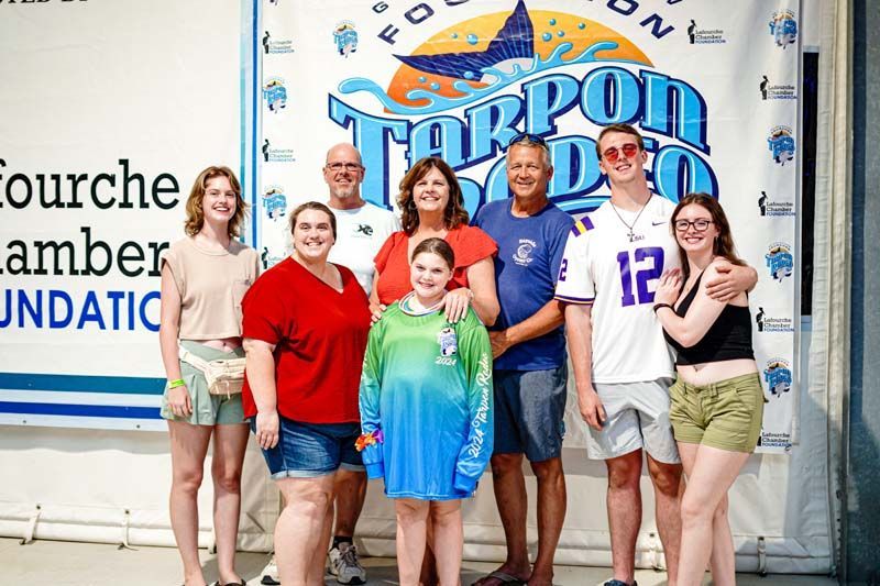 A group of people are posing for a picture in front of a banner.