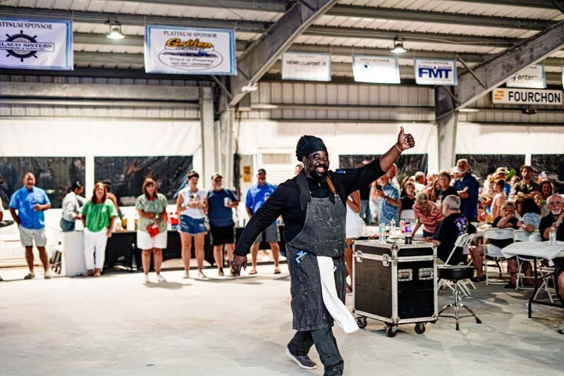 A man in an apron is dancing in front of a crowd of people.