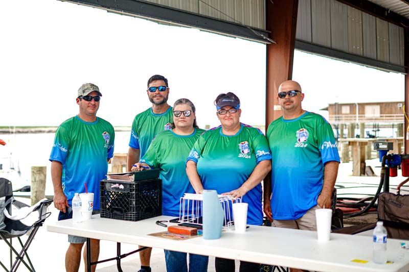 A group of people are standing around a table.