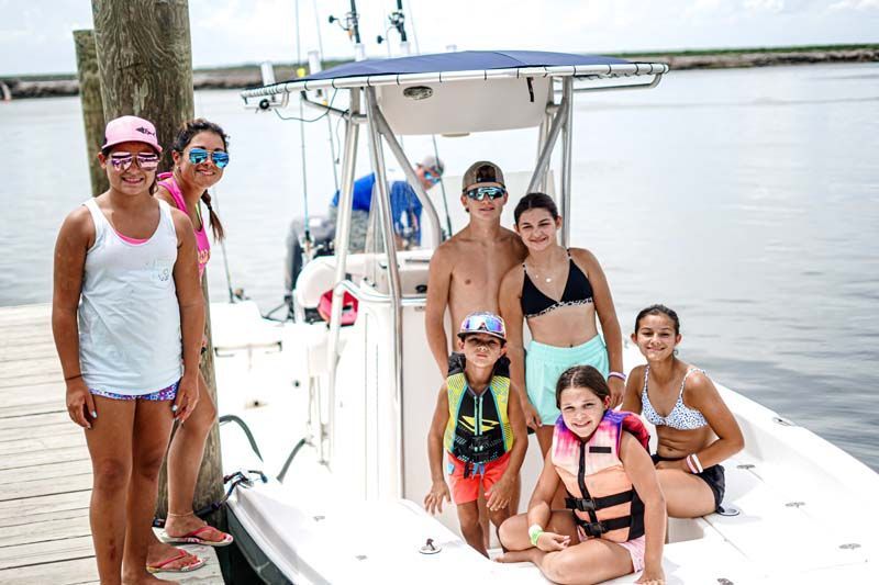 A group of children are posing for a picture on a boat.