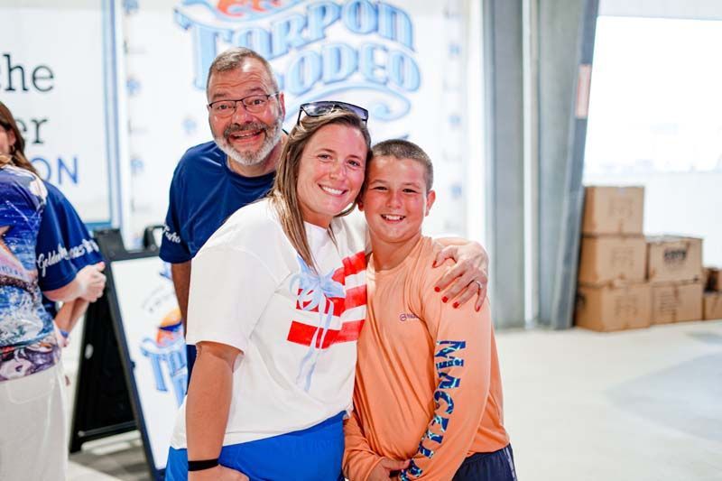 A group of people are posing for a picture in front of a sign.