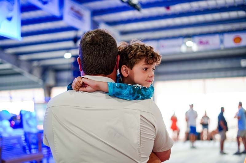 A man is holding a little boy on his shoulders.