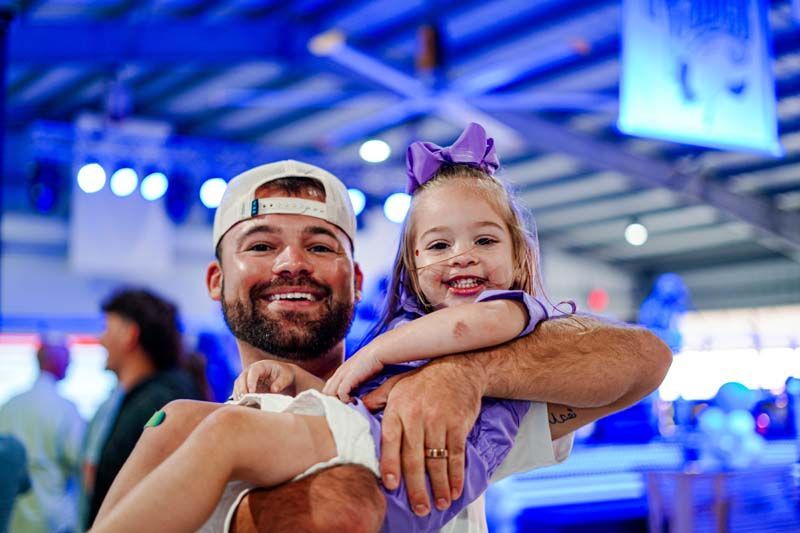 A man is holding a little girl in his arms.