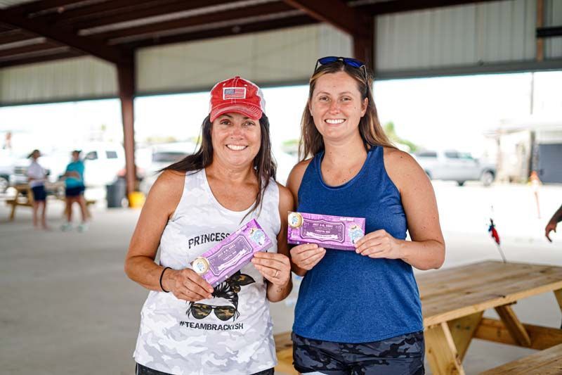 Two women are standing next to each other holding candy bars.