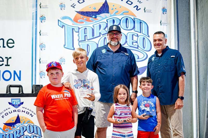 A group of people standing next to each other in front of a sign.