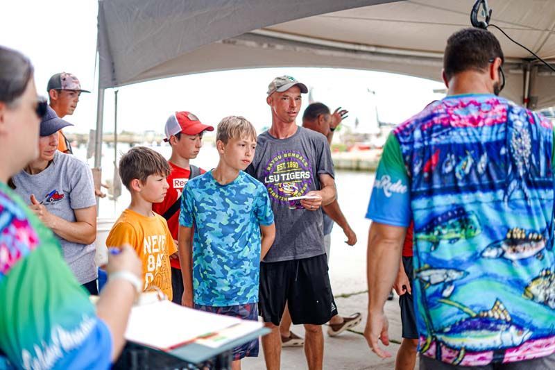 A group of people are standing under a tent.