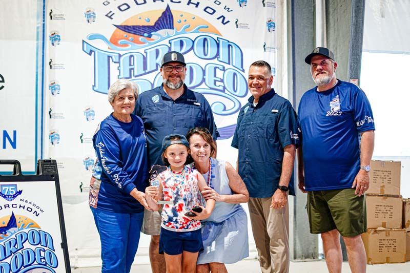 A group of people standing next to each other in front of a sign.