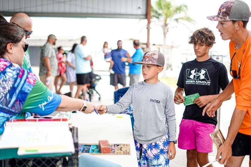 A group of people are standing around a table shaking hands.