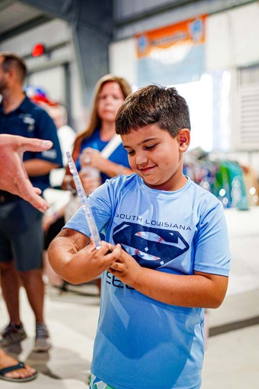 A young boy is holding a syringe in his hand.