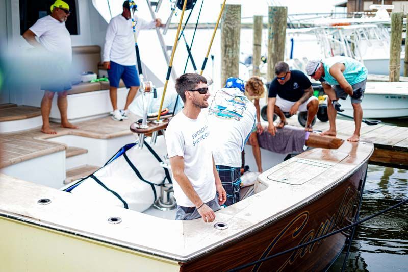 A group of men are working on a boat in the water.