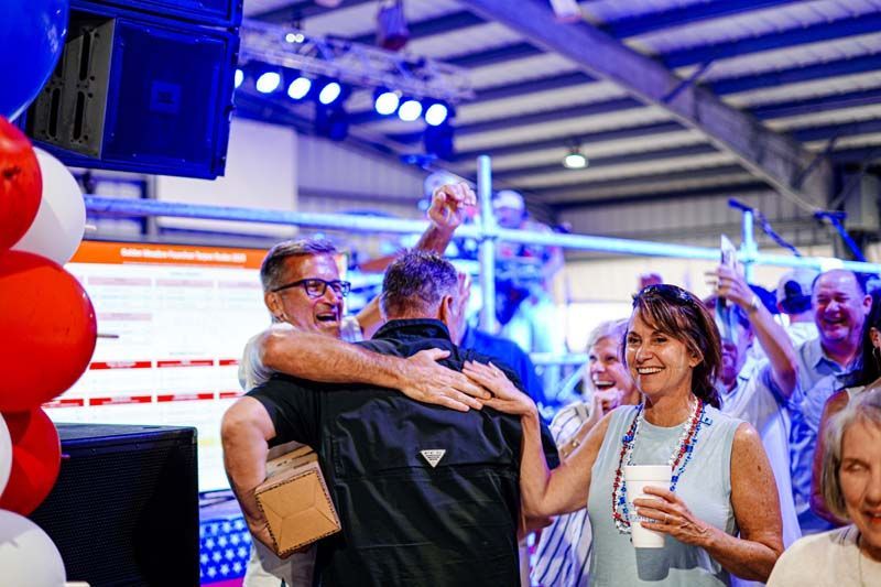 A group of people are hugging each other at a party.