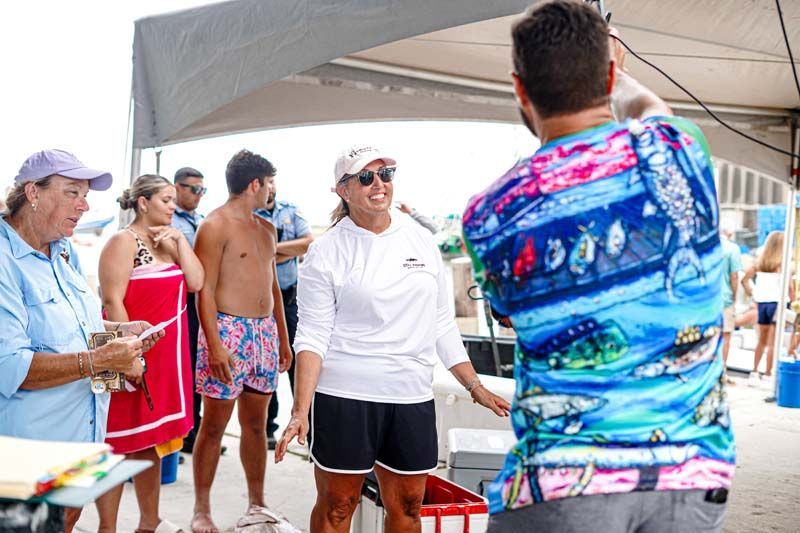 A group of people are standing under a tent on the beach.