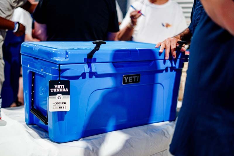 A blue yeti cooler is sitting on top of a white table.