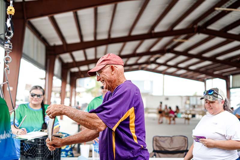 A man in a purple shirt is holding a torch in a covered area.