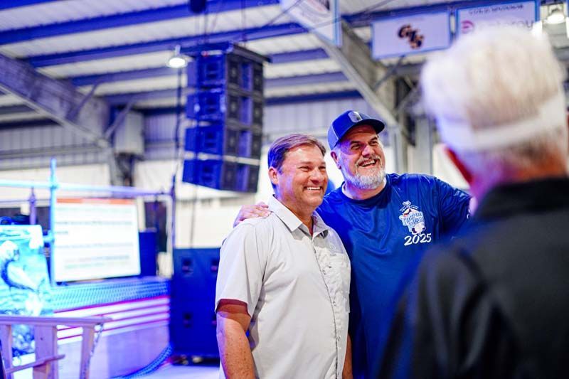 Two men are standing next to each other in a room.