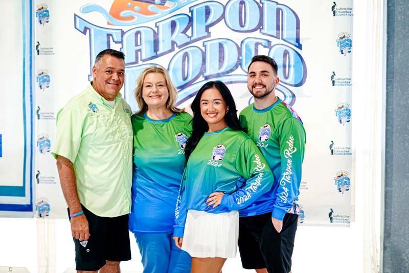 A group of people are posing for a picture in front of a sign.