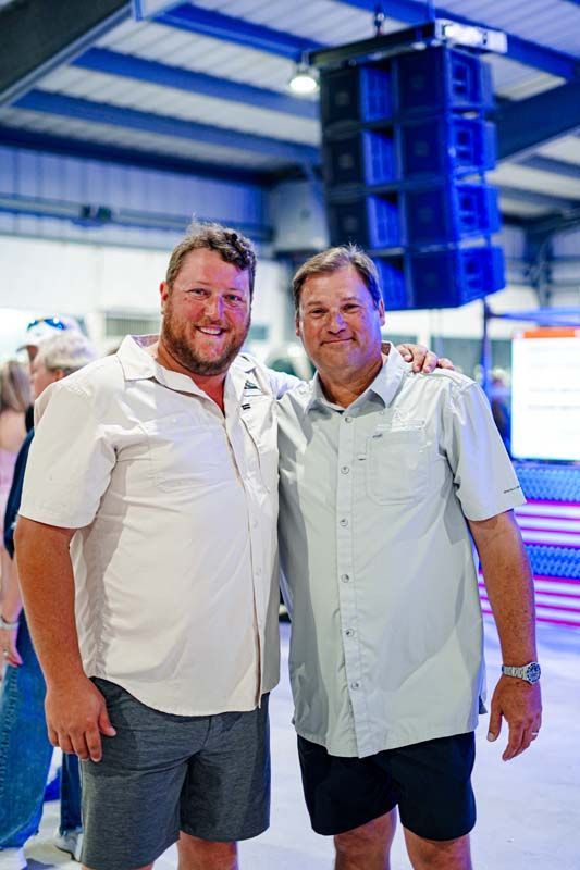 Two men are posing for a picture together in a room.