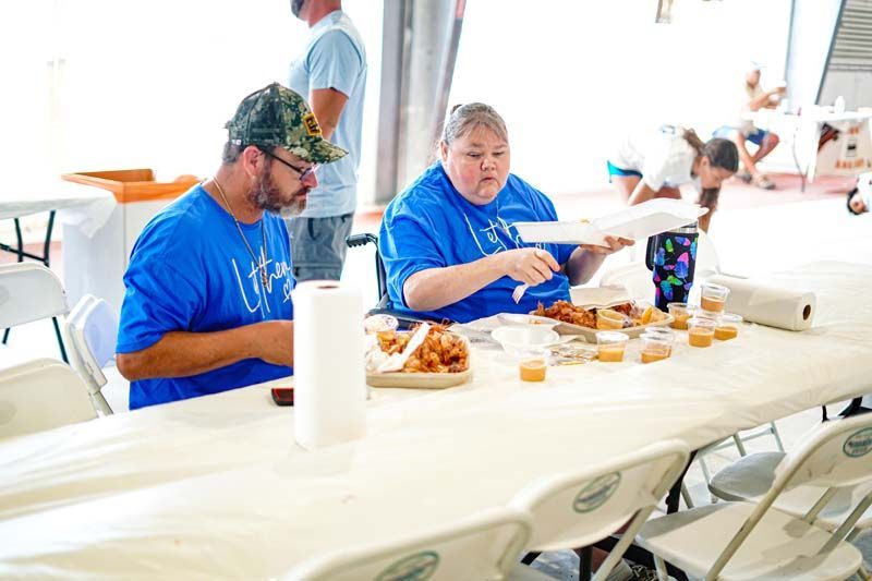 Two people are sitting at a table eating food.