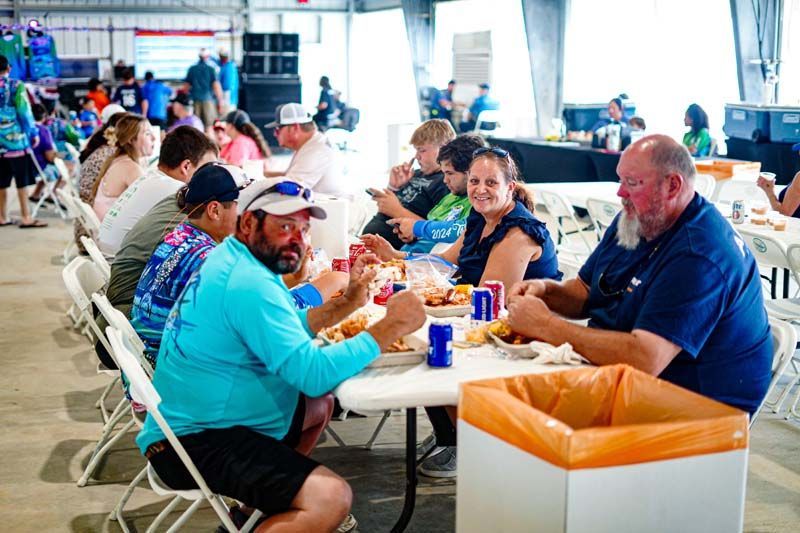 A group of people are sitting at tables eating food.