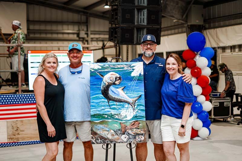 A group of people are standing around a painting of a fish.
