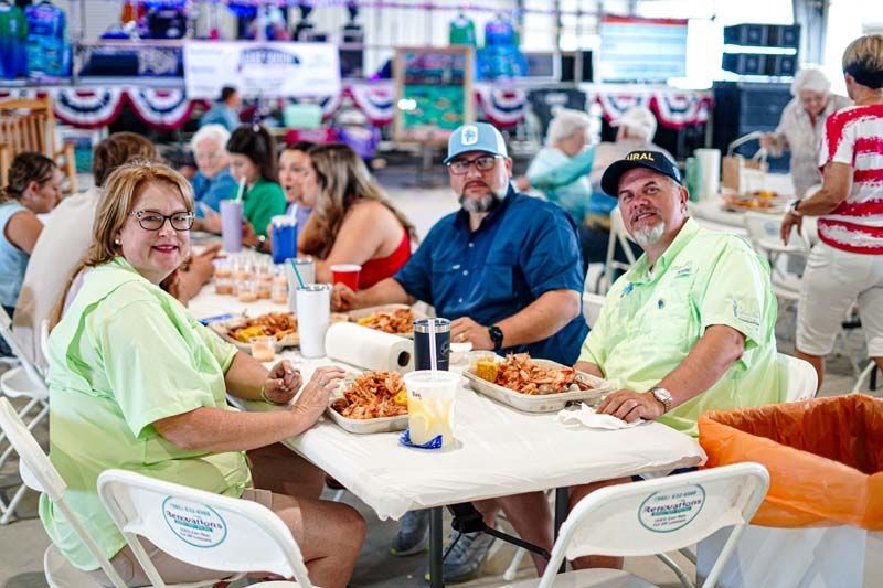 A group of people are sitting at tables eating food.