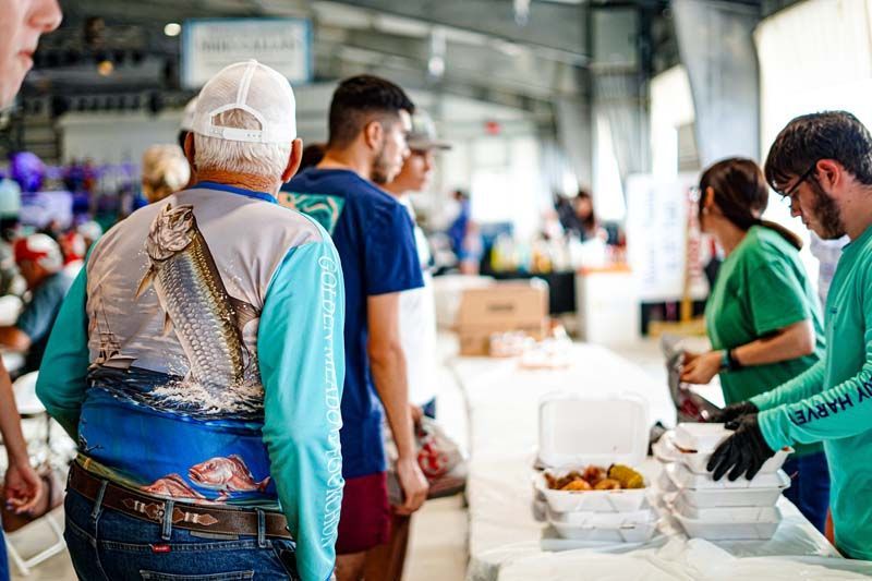 A group of people are standing in a line at a table.