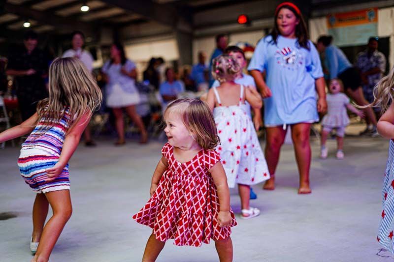 A group of little girls are dancing on a dance floor.