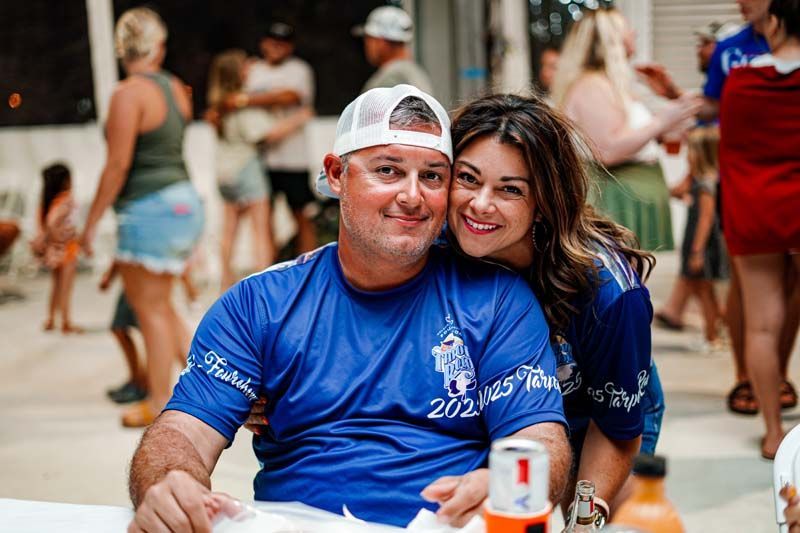 A man and a woman are posing for a picture while sitting at a table.