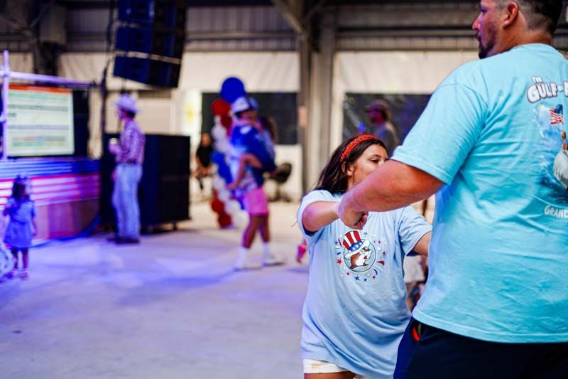 A man and a little girl are dancing in a room.