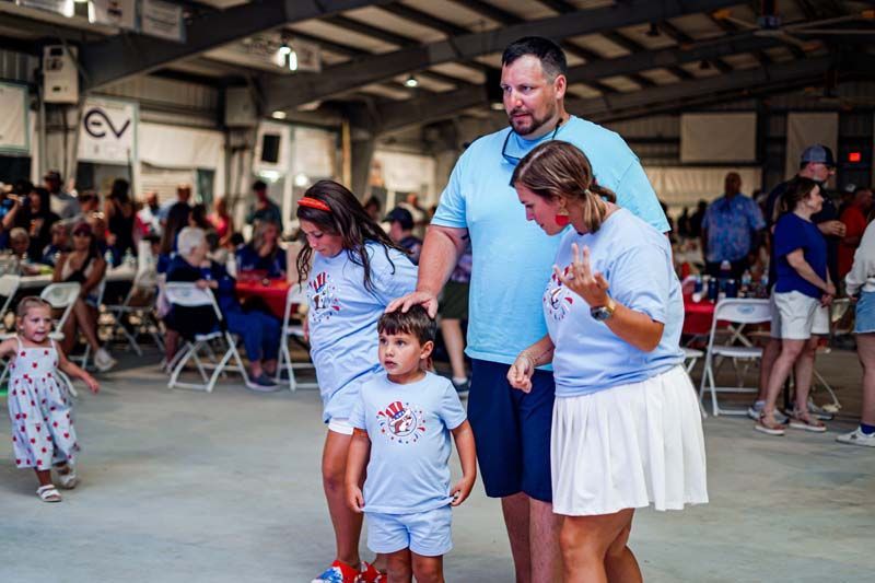 A family is standing next to each other in a room.