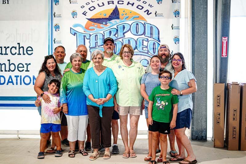 A large group of people are posing for a picture in front of a sign.