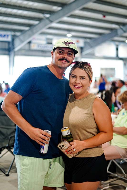 A man and a woman are posing for a picture at a picnic.