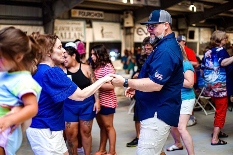 A group of people are dancing together in a room.