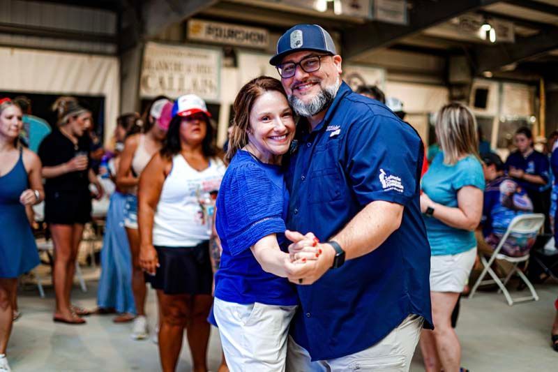 A man and a woman are dancing together in front of a crowd of people.
