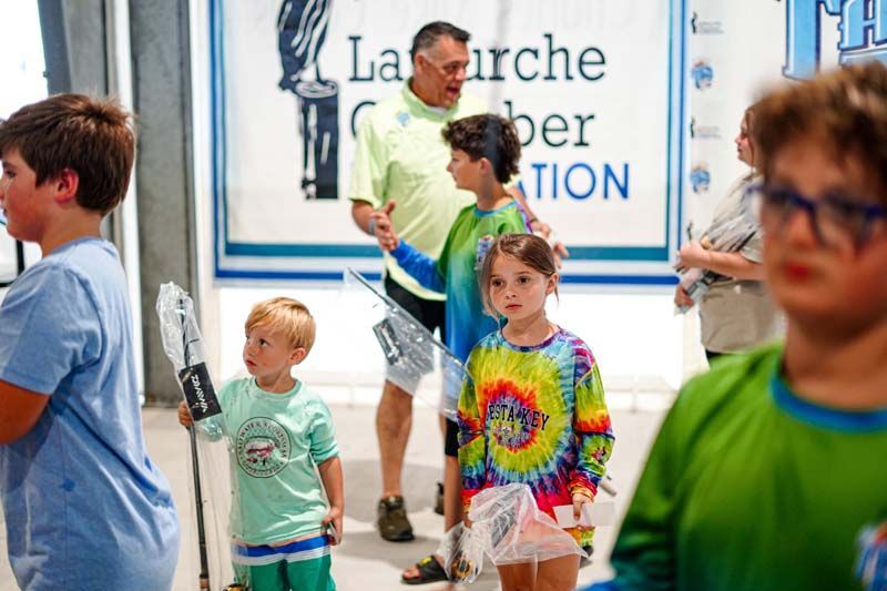 A group of children are standing in front of a sign that says la marche