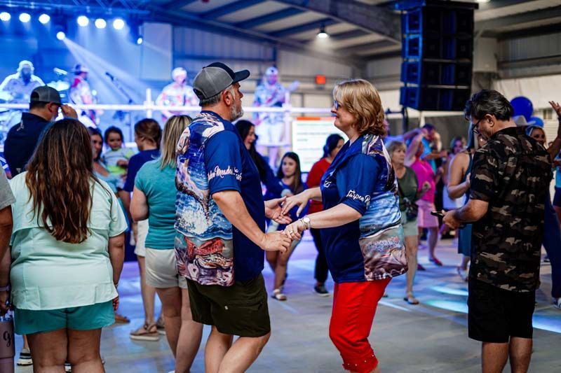 A group of people are dancing in a room at a party.