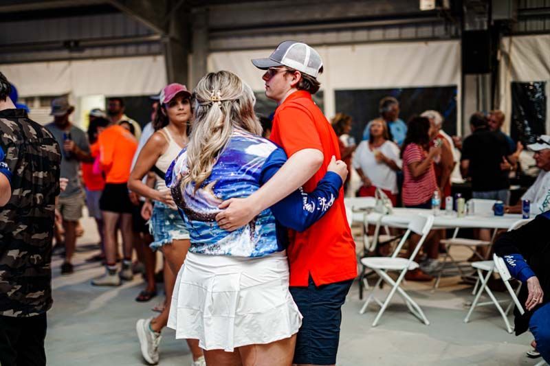 A man and a woman are dancing in front of a crowd of people.