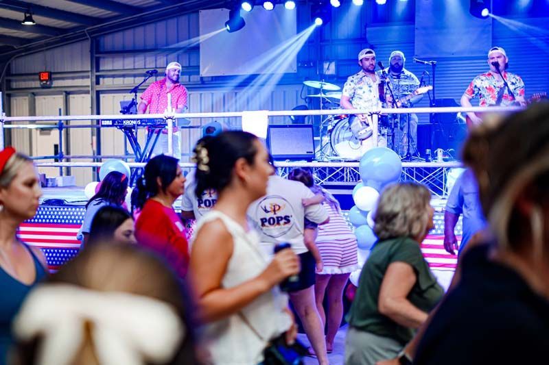 A group of people are dancing in front of a band on a stage.